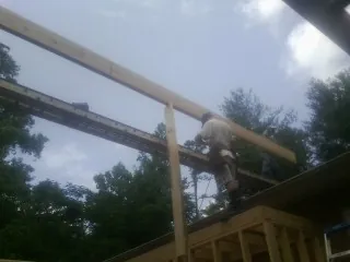 Carpenter setting a ridge beam over a new addition frame — Ice Dam Removal by Roofing Brothers in Adena