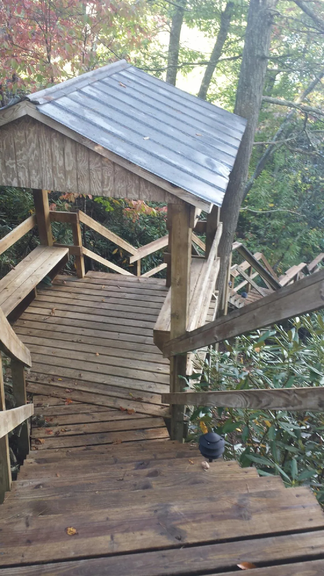 Metal roofed shelter over wooden steps on a wooded walkway — Skylight Repair & Installation work by our crew in Adena
