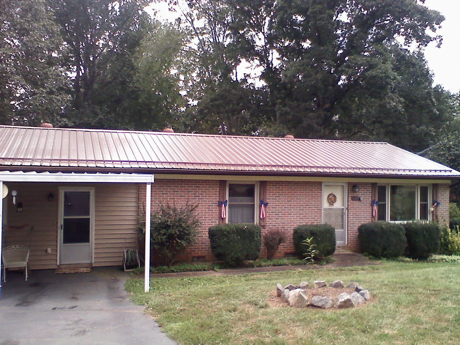 Bronze metal roof and carport on a brick ranch home — Roof Repair work by our crew in Adena